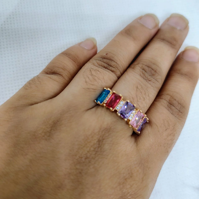Picture of vibrant gold ring adorned with colorful gemstones,