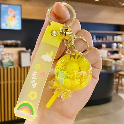 Picture of Creative Liquid Quicksand Lollipop Keychain – Cute Pastel Floating Charm Keyring with "Wish" Silicone Wristlet Strap for Bags, Keys, & Gifts (Yellow)