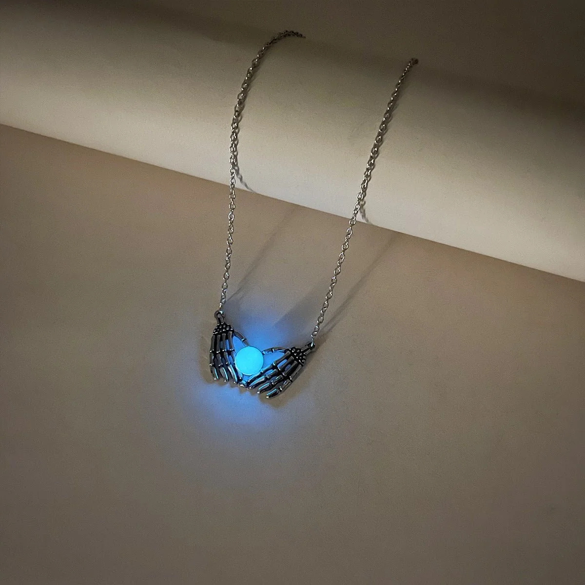 Picture of Product Description: Fashion Halloween Skull Palm Heart Pendant Luminous Necklace Add an eerie yet enchanting touch to your style with the Luminous Skull Palm Heart Pendant Necklace. Blending gothic romance with a playful, spooky vibe, this statement chok - Blue