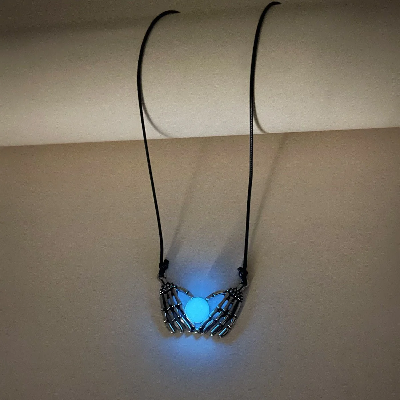 Picture of Product Description: Fashion Halloween Skull Palm Heart Pendant Luminous Necklace Add an eerie yet enchanting touch to your style with the Luminous Skull Palm Heart Pendant Necklace. Blending gothic romance with a playful, spooky vibe, this statement chok - Blue