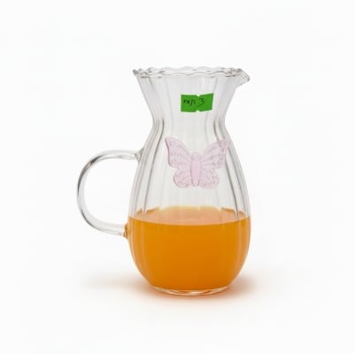 Picture of Elegant fluted borosilicate glass pitcher with pink butterfly motif and scalloped rim for serving fresh orange juice lemonade or iced tea at sophisticated garden parties brunch gatherings and stylish home dining events.
