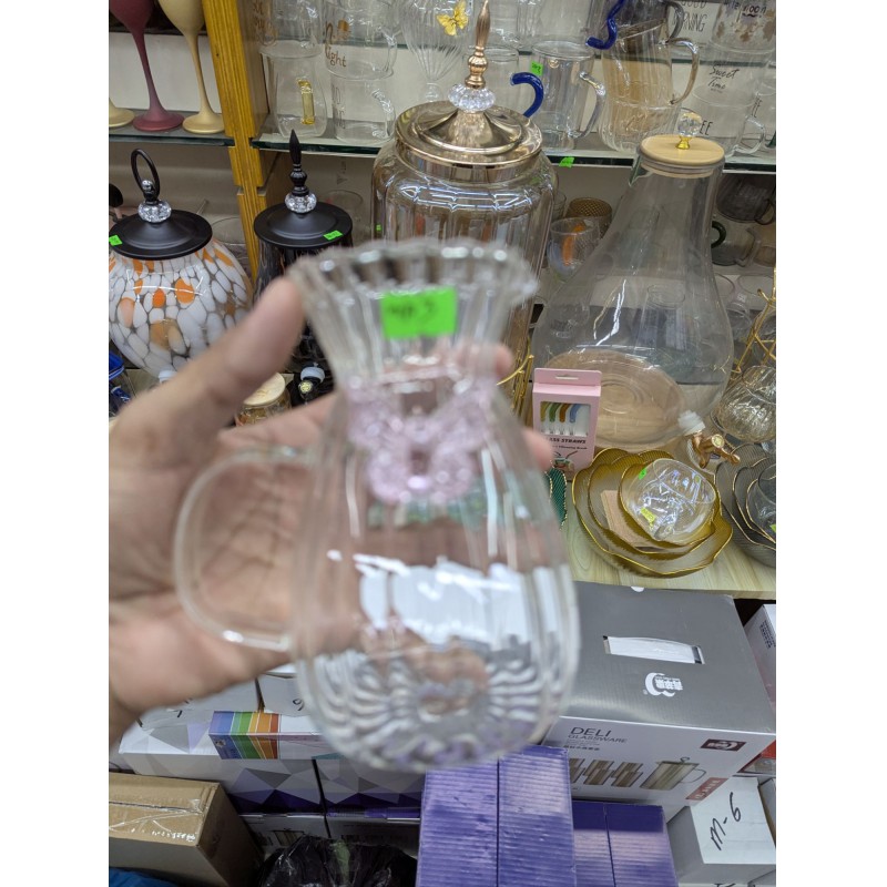 Picture of Elegant fluted borosilicate glass pitcher with pink butterfly motif and scalloped rim for serving fresh orange juice lemonade or iced tea at sophisticated garden parties brunch gatherings and stylish home dining events.