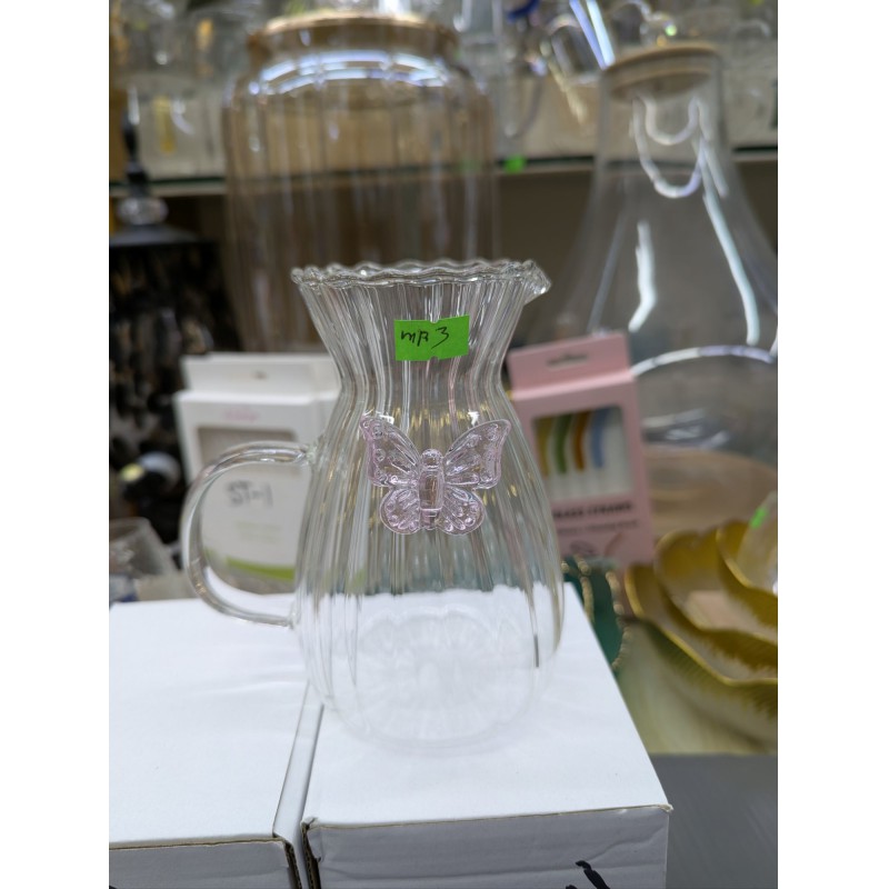 Picture of Elegant fluted borosilicate glass pitcher with pink butterfly motif and scalloped rim for serving fresh orange juice lemonade or iced tea at sophisticated garden parties brunch gatherings and stylish home dining events.