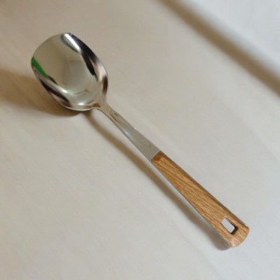 Picture of 10 Inch Stainless Steel Solid Turner Spoon, Silver, Non-Magnetic. Wooden Color Cover Plastic Handle for Comfortable Grip. Ideal for Cooking and Serving, Effortless Flipping in Any Kitchen.-Silver