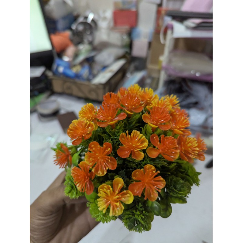 Picture of Premium Artificial Orange Flower Pot for Home Office Table Decoration realistic vibrant faux plant with black plastic weave basket base perfect for living room desk shelf or balcony indoor styling.-Multicolor