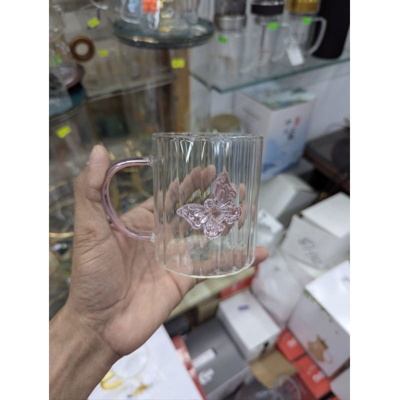 Picture of Elegant 3D butterfly high borosilicate glass mug featuring a heat resistant vertical striped fluted design and pink colored handle perfect for hot coffee herbal tea or as a charming decorative kitchen accessory.-Multicolor