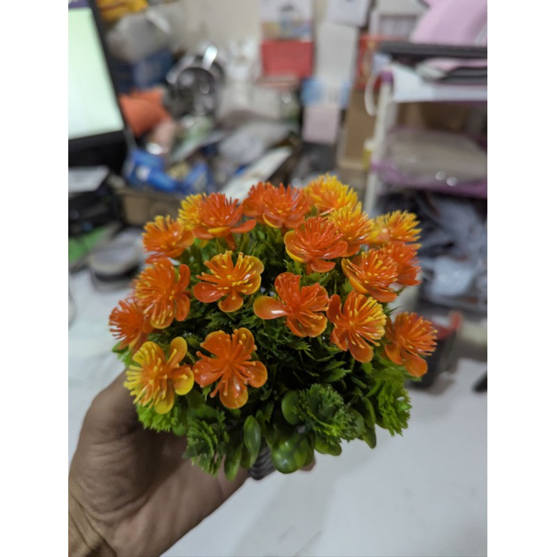 Picture of Premium Artificial Orange Flower Pot for Home Office Table Decoration realistic vibrant faux plant with black plastic weave basket base perfect for living room desk shelf or balcony indoor styling.-Multicolor