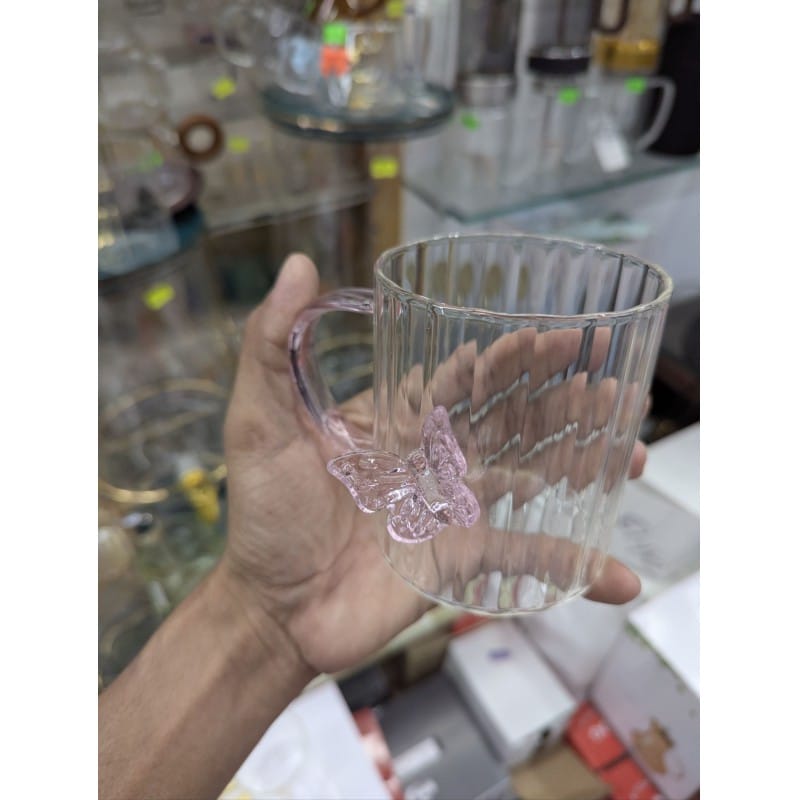 Picture of Elegant 3D butterfly high borosilicate glass mug featuring a heat resistant vertical striped fluted design and pink colored handle perfect for hot coffee herbal tea or as a charming decorative kitchen accessory.-Multicolor