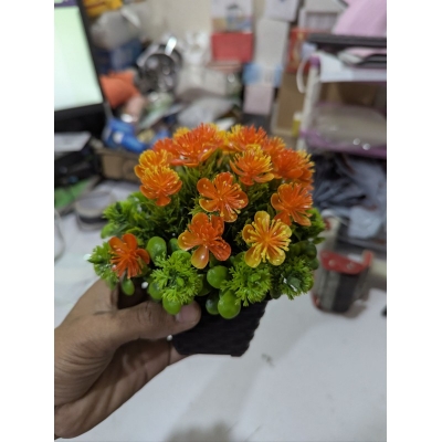 Picture of Premium Artificial Orange Flower Pot for Home Office Table Decoration realistic vibrant faux plant with black plastic weave basket base perfect for living room desk shelf or balcony indoor styling.-Multicolor